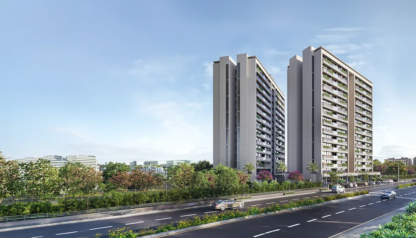 Rivanta Aurovile twin residential towers beside a tree-lined road