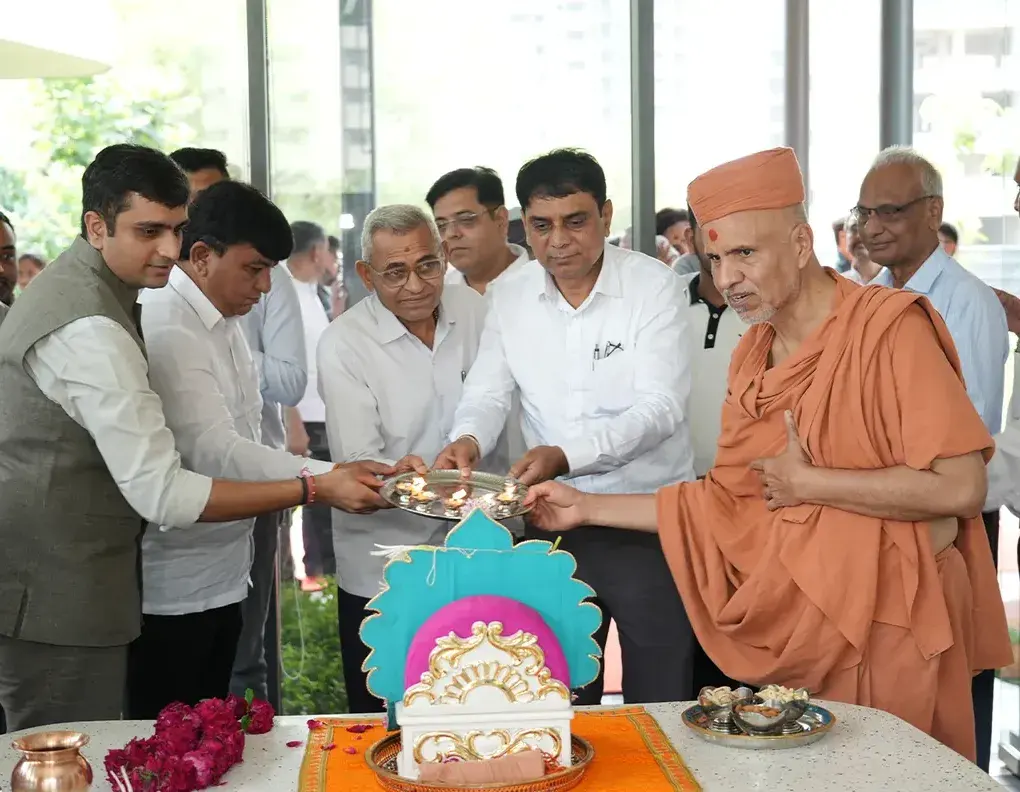 Leaders lighting the ceremonial lamp with a saint at a Pramukh Omkar inauguration