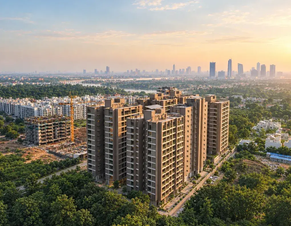 A Rivanta residential tower rising above the trees of Gandhinagar at sunset
